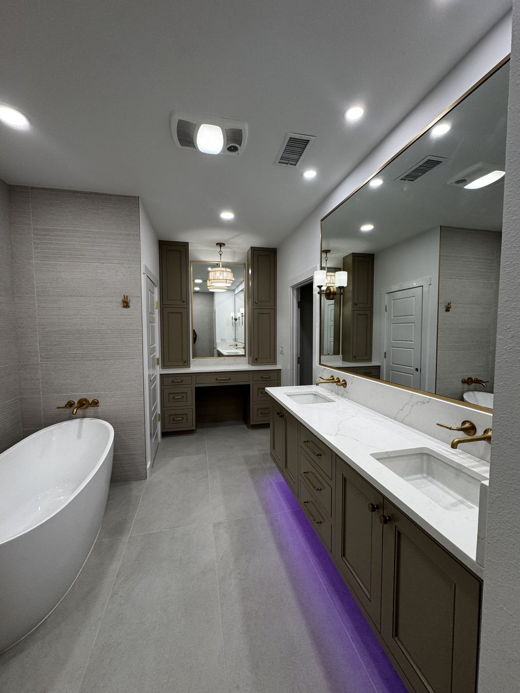 Primary bathroom with freestanding tub, double vanity and brass fixtures