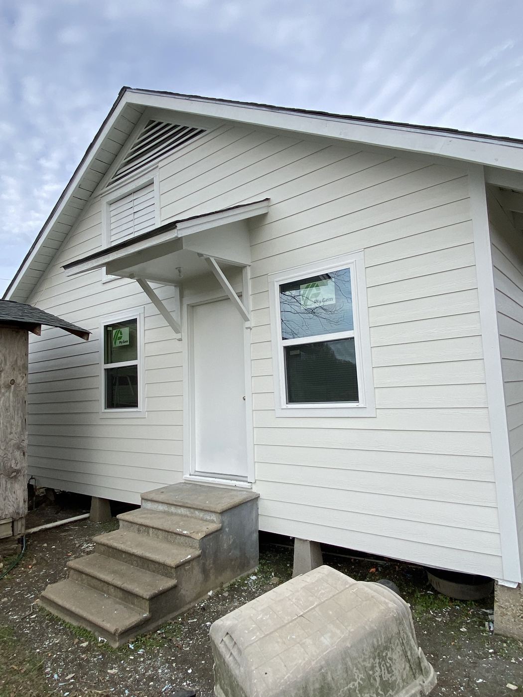 Freshly painted white house with new siding and entry steps