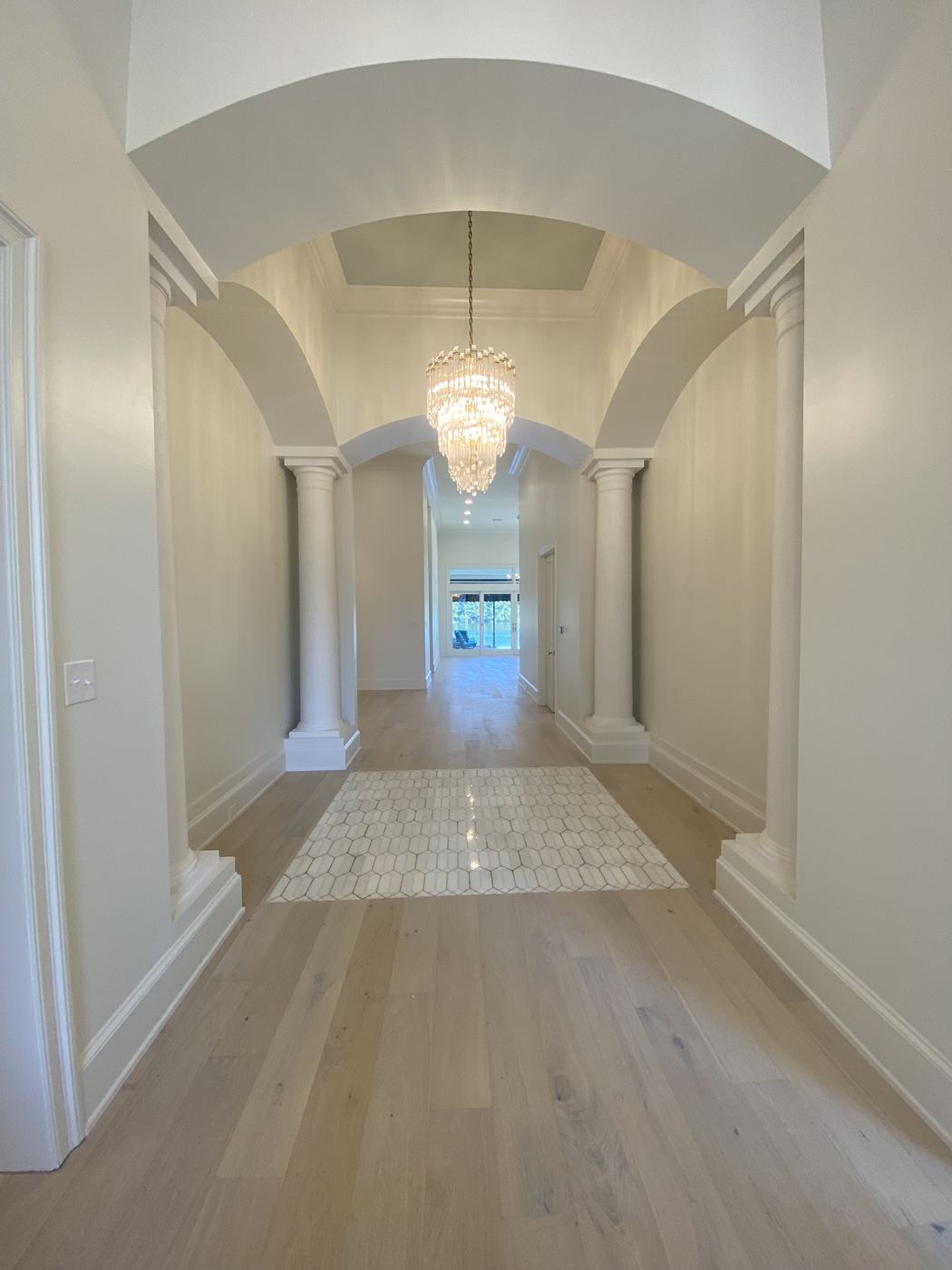 Vaulted hallway with columns and an inlaid tile floor