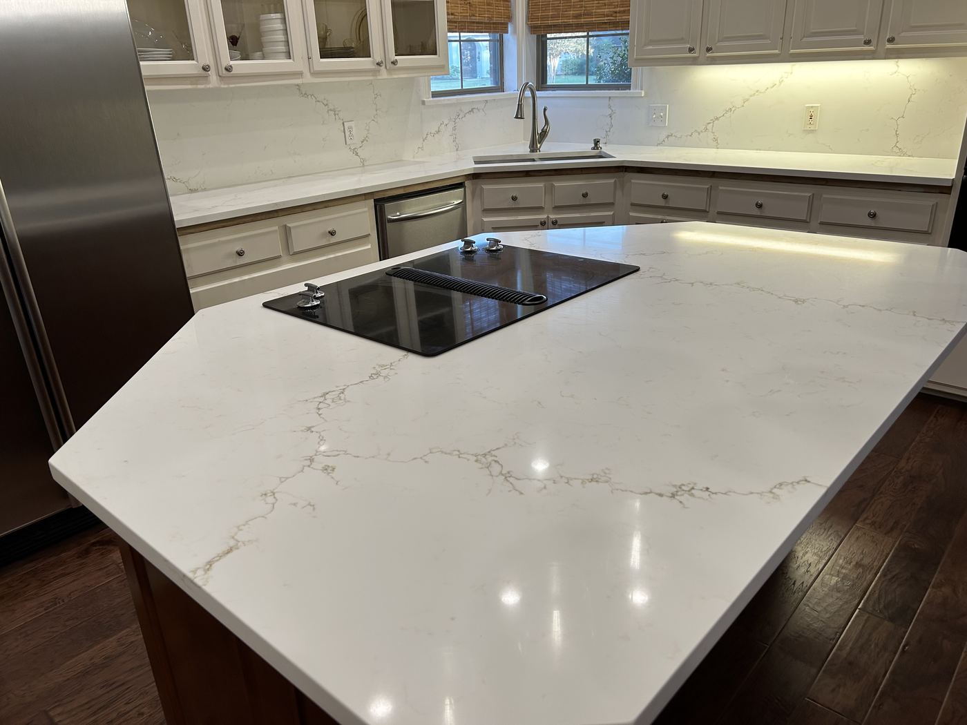 Kitchen with white quartz island and cooktop