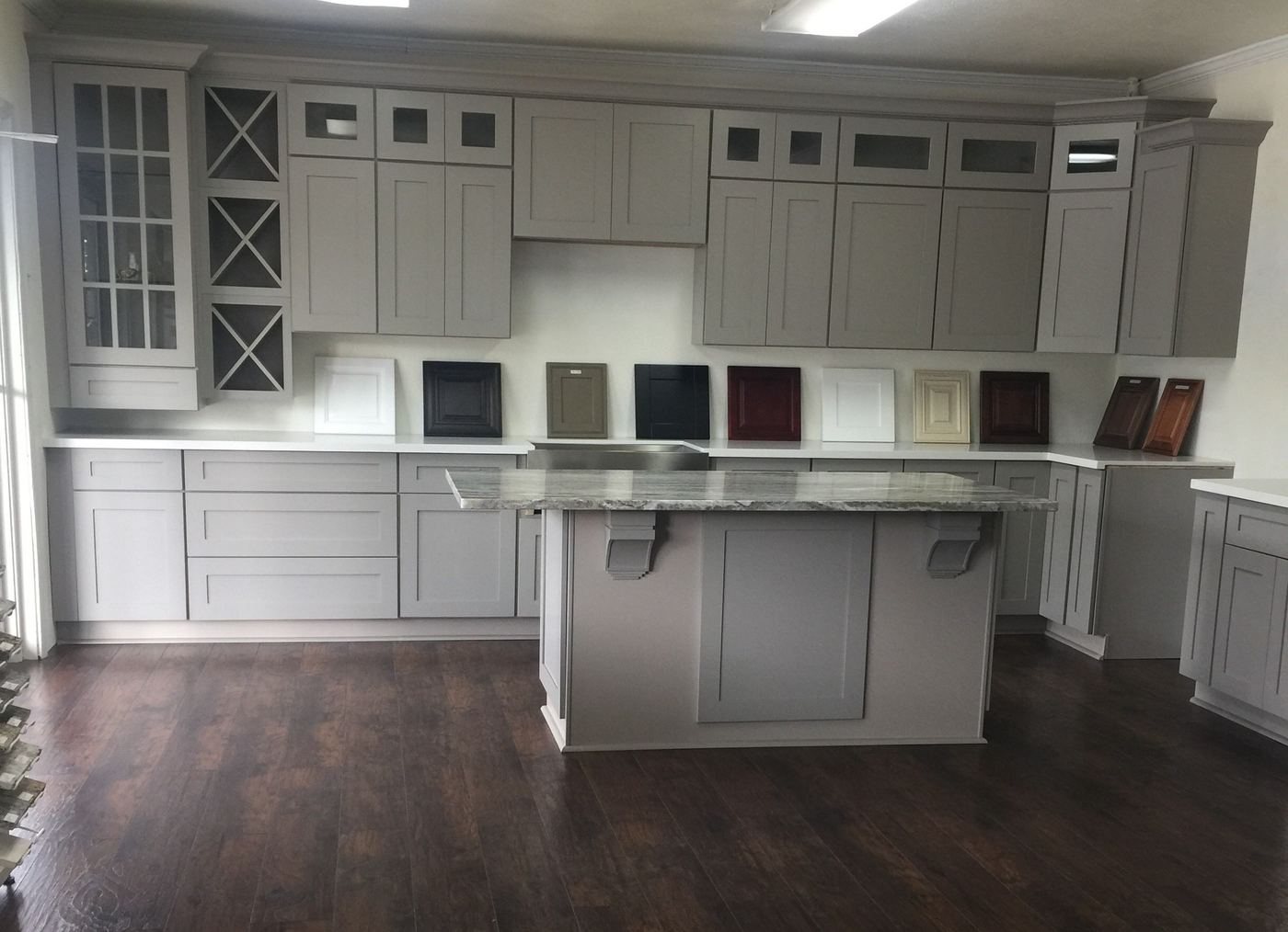 Gray shaker cabinets with an island and plank flooring