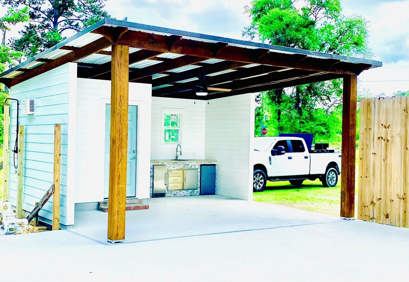 Covered outdoor kitchen under a cedar pergola